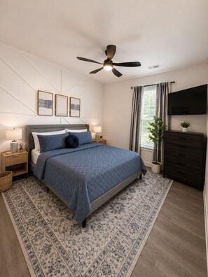 A bedroom with a bed, nightstands, a ceiling fan, a TV, and a window with curtains.