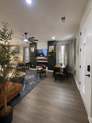 Una sala de estar moderna con chimenea, comedor y televisor.