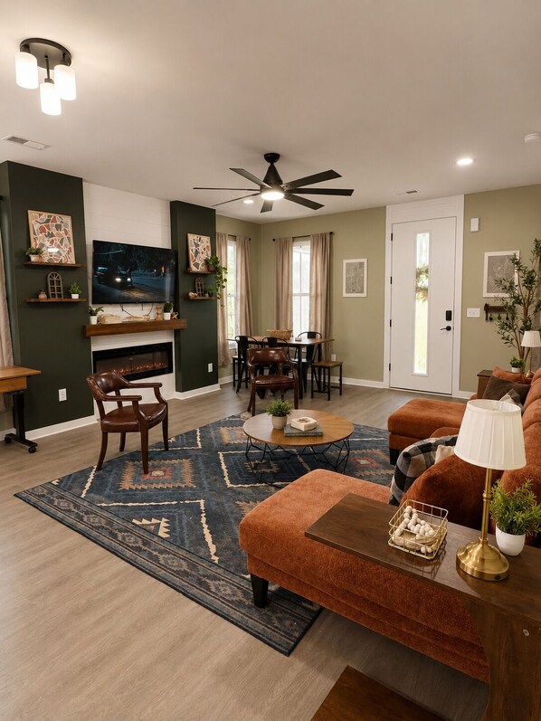 A living room with a fireplace, television, dining area, and seating.