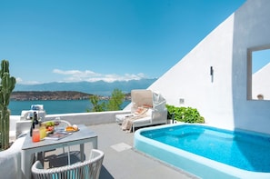 A poolside area with a view of the sea, a table with drinks and food, and a covered lounge chair. - Dali MISTY HAVEN CAVE VILLA (Dali)