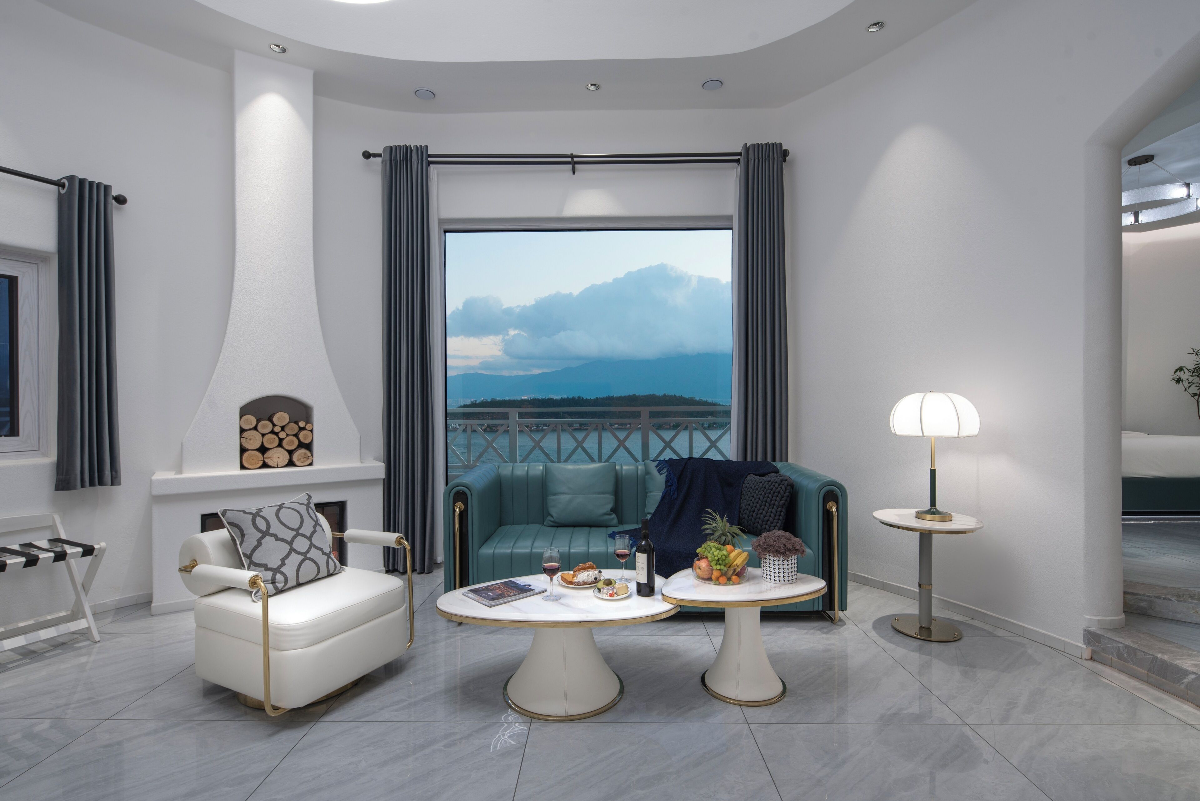 A modern living room with a sofa, two coffee tables, and a view of the sea.
