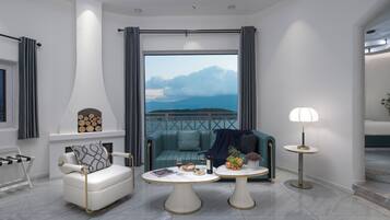 A modern living room with a sofa, two coffee tables, and a view of the sea.