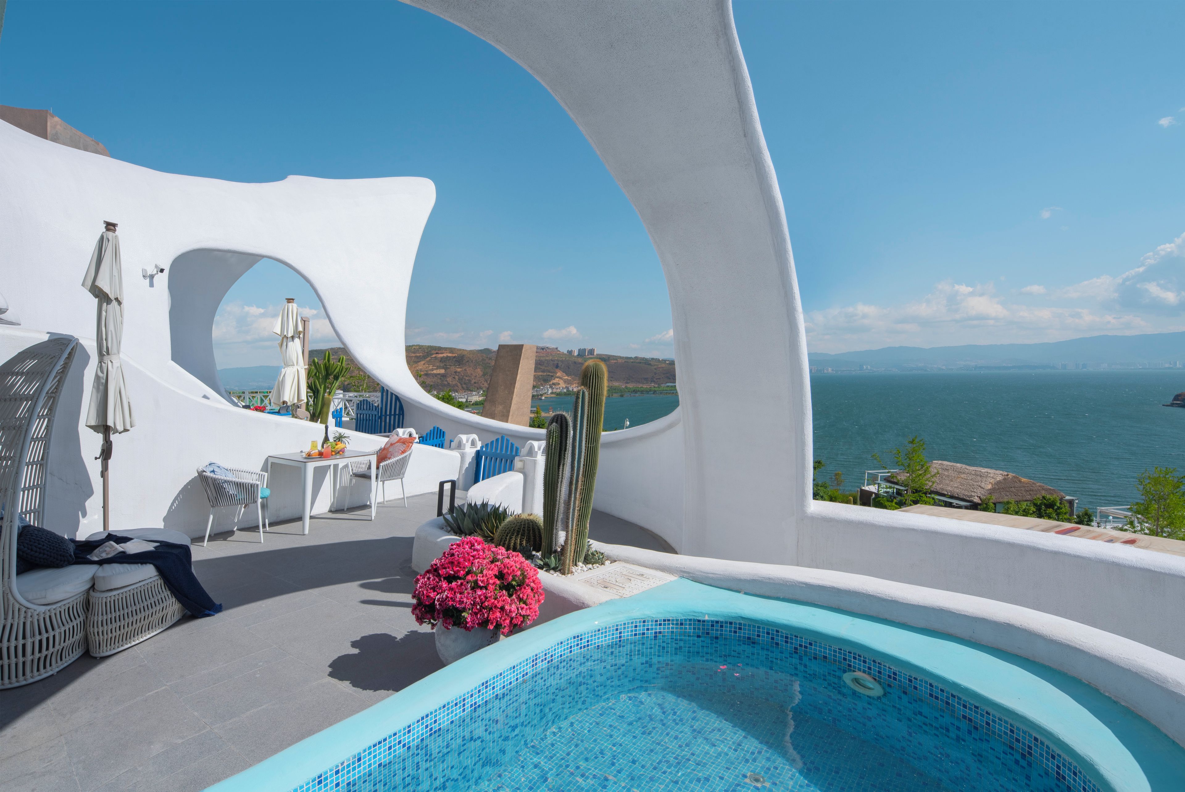 Un área de piscina moderna al aire libre con vistas al mar y un diseño arquitectónico único.