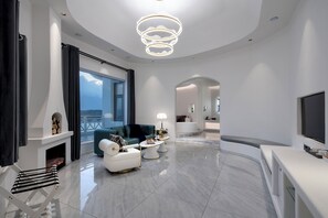 A modern living room with a fireplace, a sofa, a coffee table, and a TV. - Dali MISTY HAVEN CAVE VILLA (Dali)