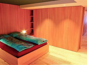 A bedroom with a built-in bed, wooden wardrobe, and a bedside shelf. - Beautiful apartment for 4 people with WIFI, TV and balcony (Zermatt)