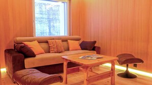 A cozy room with a sofa, a wooden coffee table, and a chair. - Nice apartment for 4 people with WIFI, TV and balcony (Zermatt)