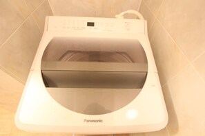 A Panasonic appliance, likely a dryer, in a room with tiled walls. - Spacious Private Stay Near Higashi-Shinjuku | Sleeps 10 | Families & Groups | WiFi (1) (新宿区新宿７丁目)