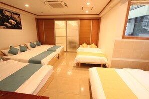 A hotel room with three beds, a sliding door, and a window. - Spacious Private Stay Near Higashi-Shinjuku | Sleeps 10 | Families & Groups | WiFi (1) (新宿区新宿７丁目)
