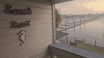 A view from a balcony overlooking a marina with a wooden railing and a seahorse decoration on the wall.