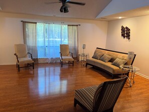 A living room with a sofa, two armchairs, a coffee table, and a ceiling fan. - 3-bedroom house in superb Alexander with cool AC (Alexander)
