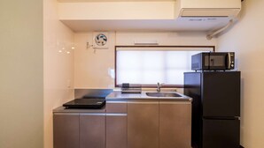 Eine kleine Küche mit Einbau-Mikrowelle, Spüle und Kühlschrank.