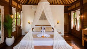 A room with a bed under a canopy, wooden walls, a potted plant, and wall-mounted lights. - Ubud 1BR Villa Resort Wooden Nakula (Ubud)