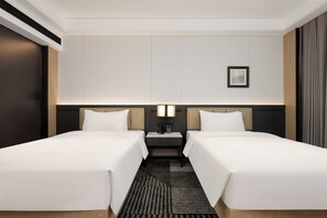 A hotel room with two single beds, a nightstand with a lamp, a framed picture on the wall, and a patterned rug. - Madison Hotel Guangzhou Panyu Chimelong Wanbo Center (Guangzhou)