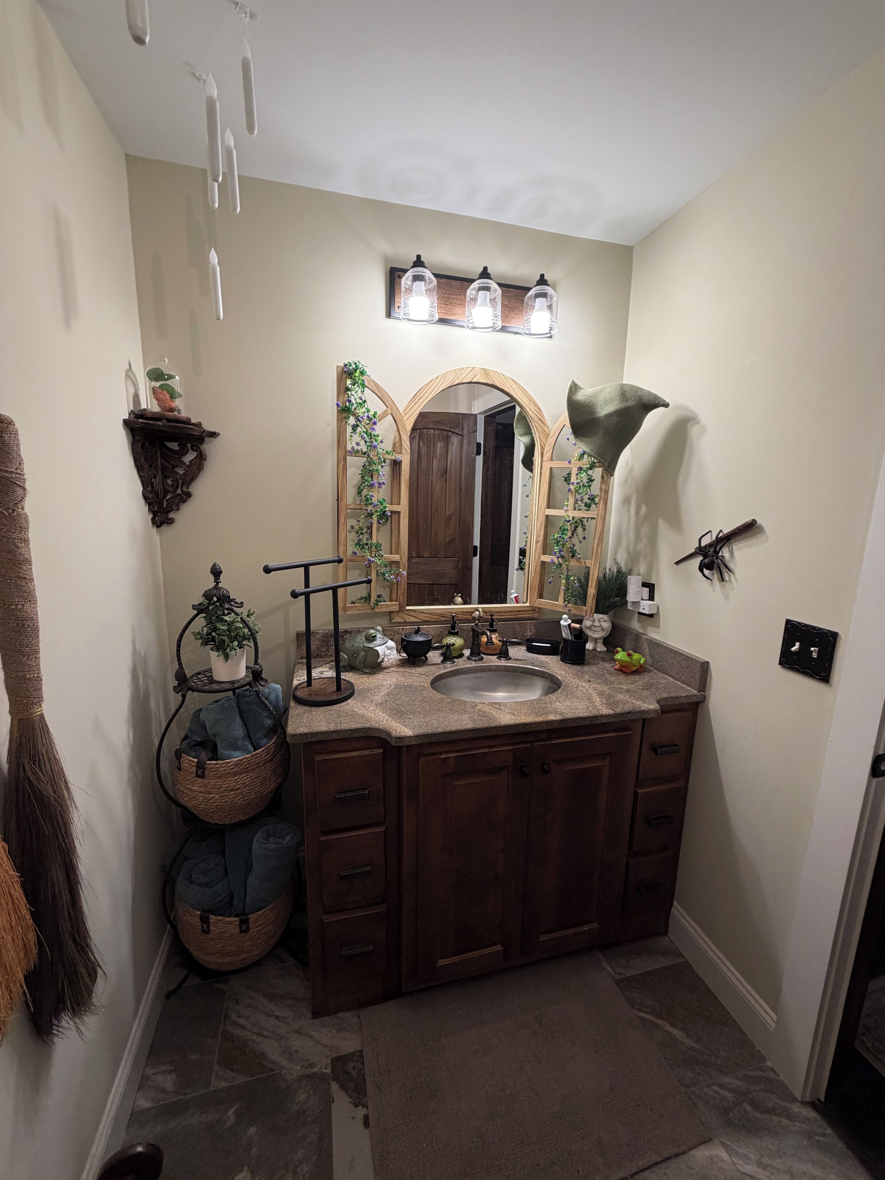 A bathroom with a wooden vanity, a large mirror, and a sink.