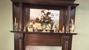 A fireplace with a mantel decorated with figurines and a vase of flowers.