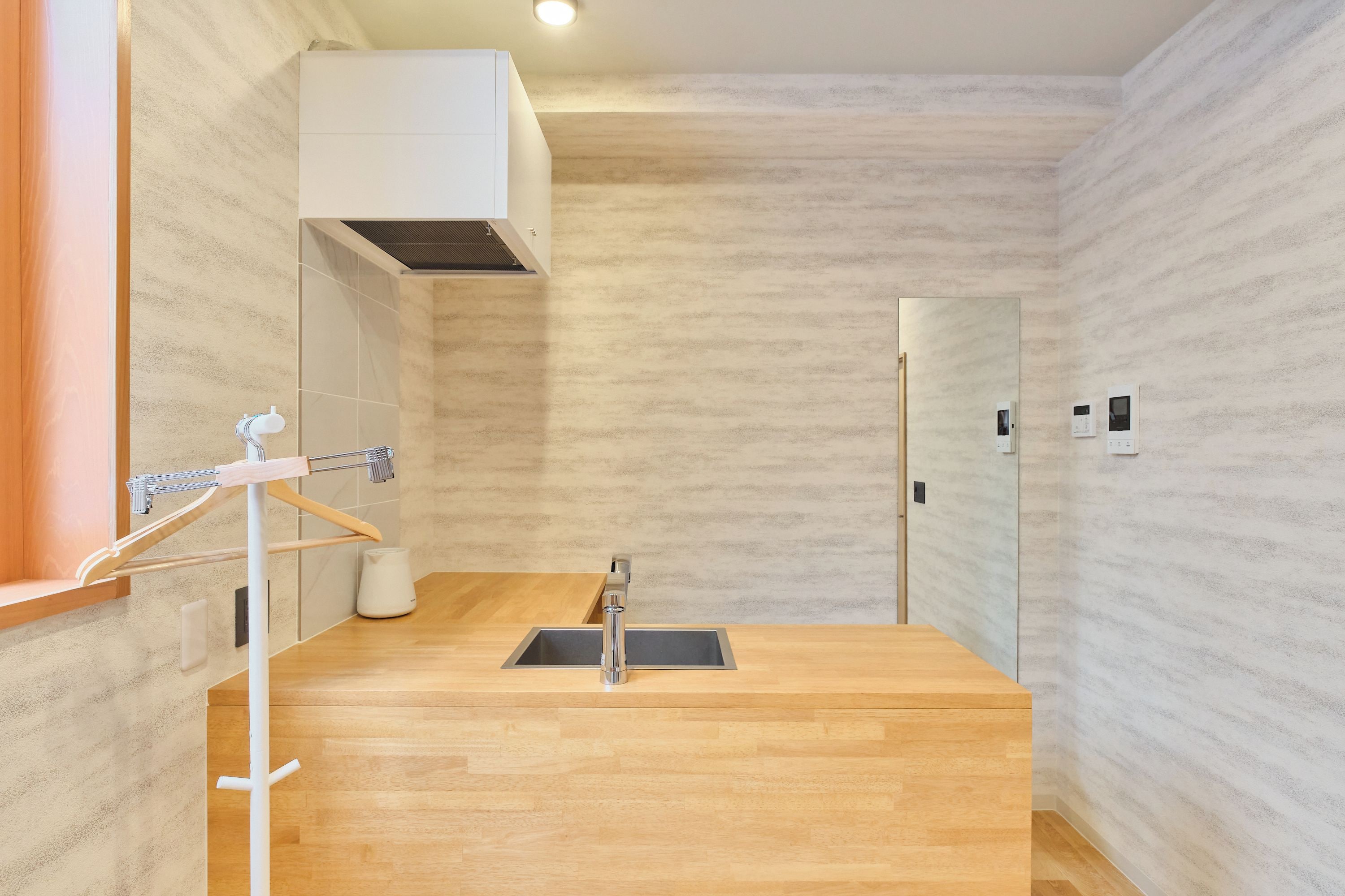 Ein modernes Badezimmer mit einem Holzbadezimmer, einem Waschbecken und einem Handtuchhalter.