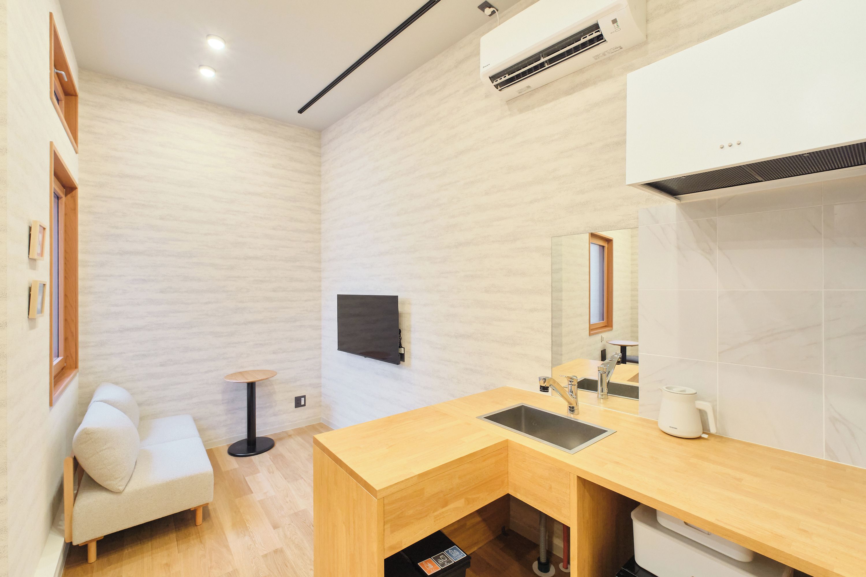 A modern bathroom with a wooden vanity, a built-in sink, and a wall-mounted mirror.