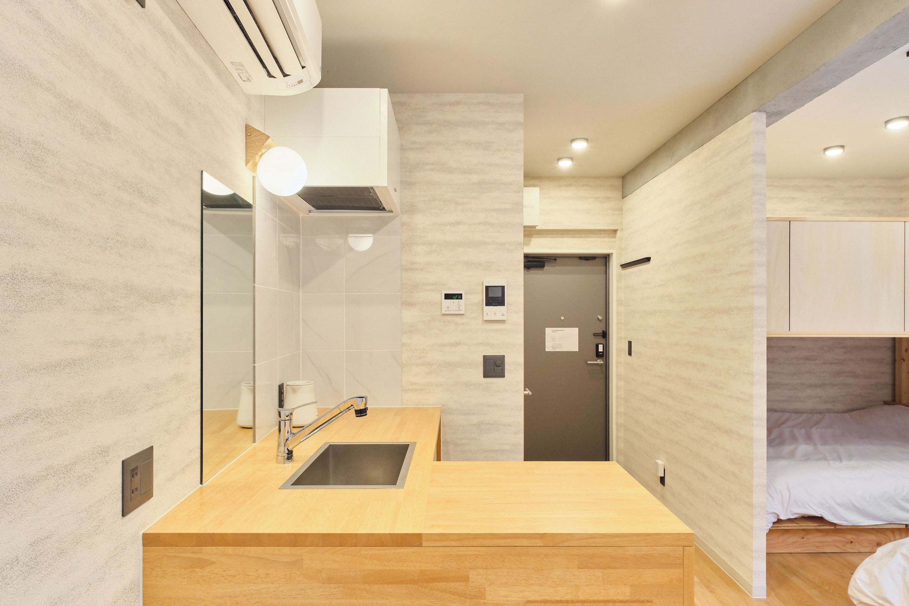 A modern bathroom with a wooden vanity, a mirror, and a shower area.