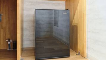 A modern, minimalist room with a built-in, dark-colored, glass-fronted cabinet.