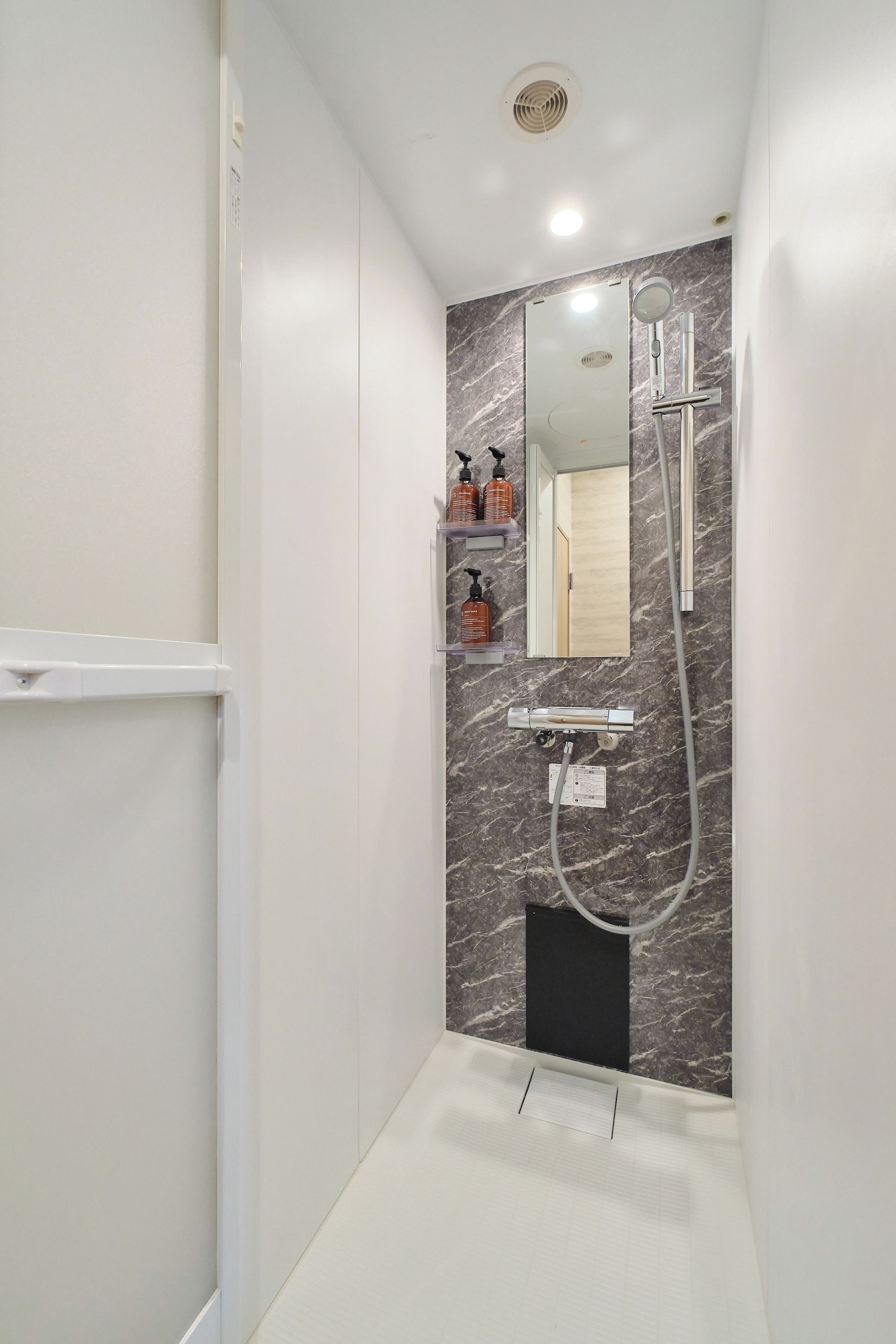Ein modernes Badezimmer mit Dusche, Waschbecken und Spiegel.