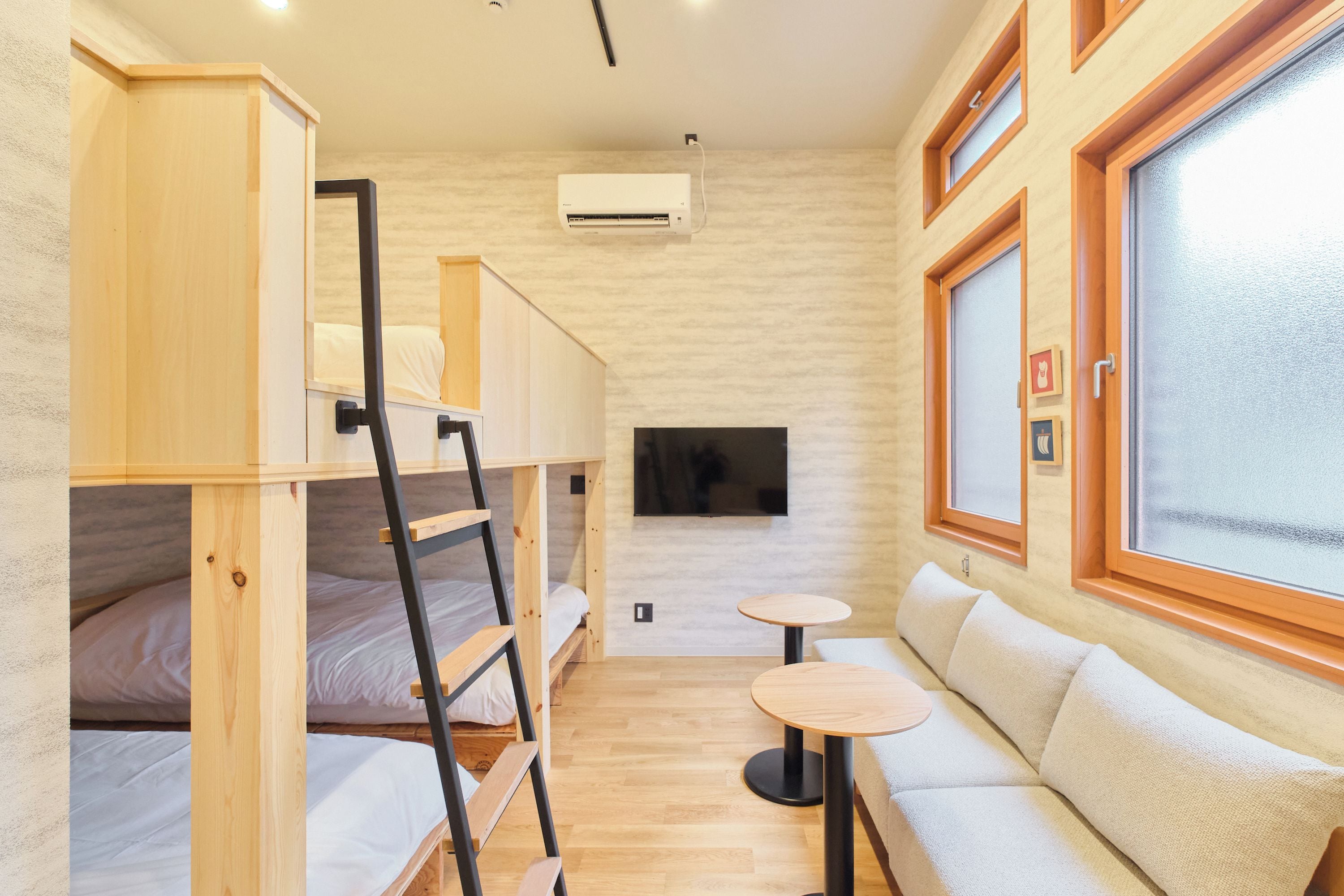 A compact room with bunk beds, a sofa, a small table, and a TV.