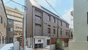 Um edifício moderno com fachada de tijolos, grandes janelas e telhado plano.