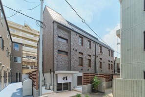 A modern building with a brick facade, large windows, and a flat roof. - Tomori (Shinjuku-ku)