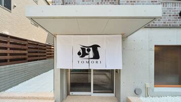 A building entrance with a banner displaying the name 'TOMORI'.