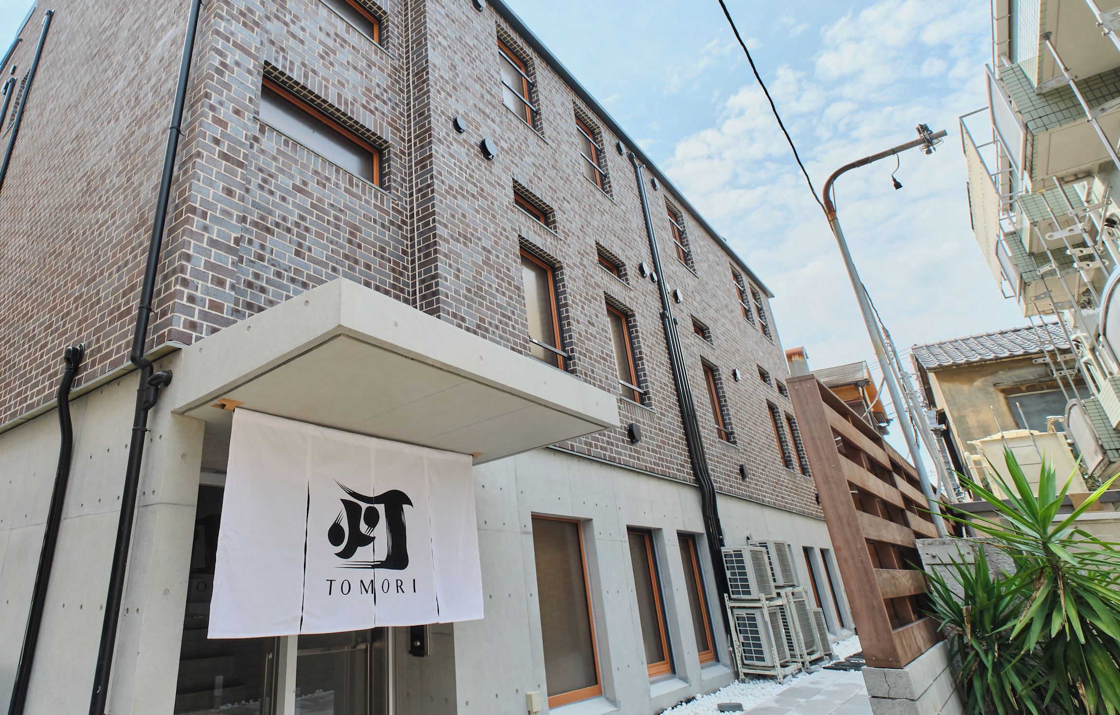 A multi-story building with a brick facade, large windows, and a flat entrance area.