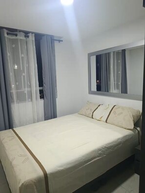 A single bed with a headboard, a bedside table, and a mirror above it. - Hermoso apartamento amoblado en Meléndez City 403 (Cali)
