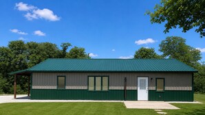 A single-story building with a green roof and a white door, surrounded by a well-maintained lawn and trees. - Rustic Cabin Escape in Welcoming Brown County. Reconnect, Relax & Unwind (Mount Sterling)