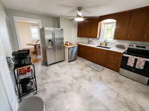Eine Küche mit Kühlschrank, Geschirrspüler, Backofen und Holzschränken.
