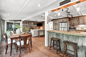 Eine moderne Küche mit Steinwand, Holzschränken und einer Bar.