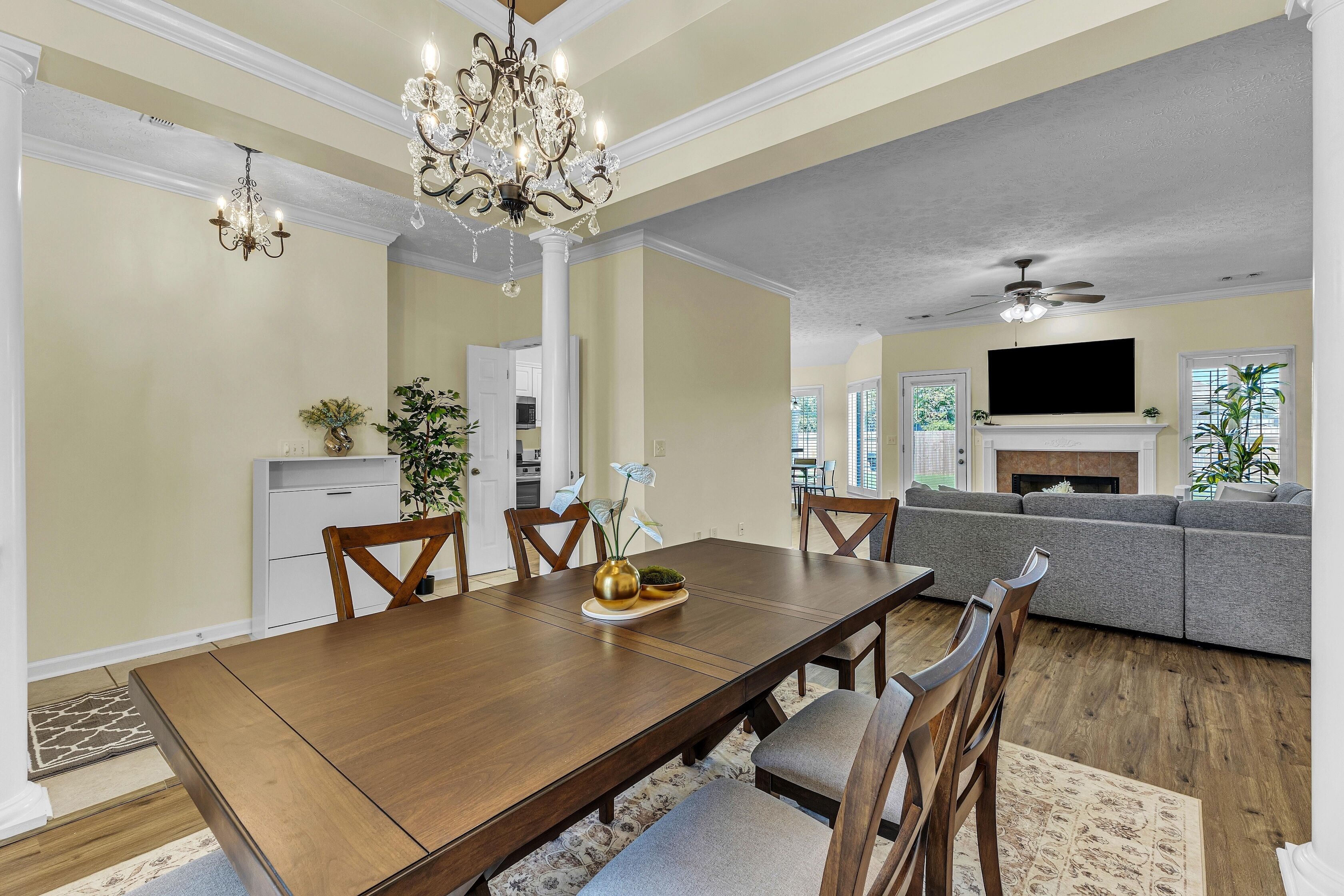 A dining area with a wooden table, chairs, and a chandelier.