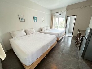 Ein Hotelzimmer mit zwei Betten, einem Kühlschrank und einem Balkon.