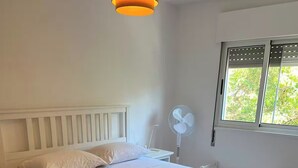 Una camera da letto con un letto, un comodino e una finestra con vista.