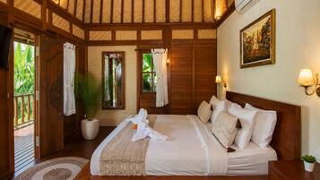 A bedroom with a large bed, wooden beams, a potted plant, and a painting on the wall.