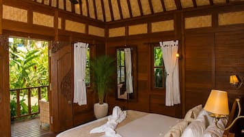Una habitación con cama, ventilador de techo, planta en maceta y vistas al exterior.