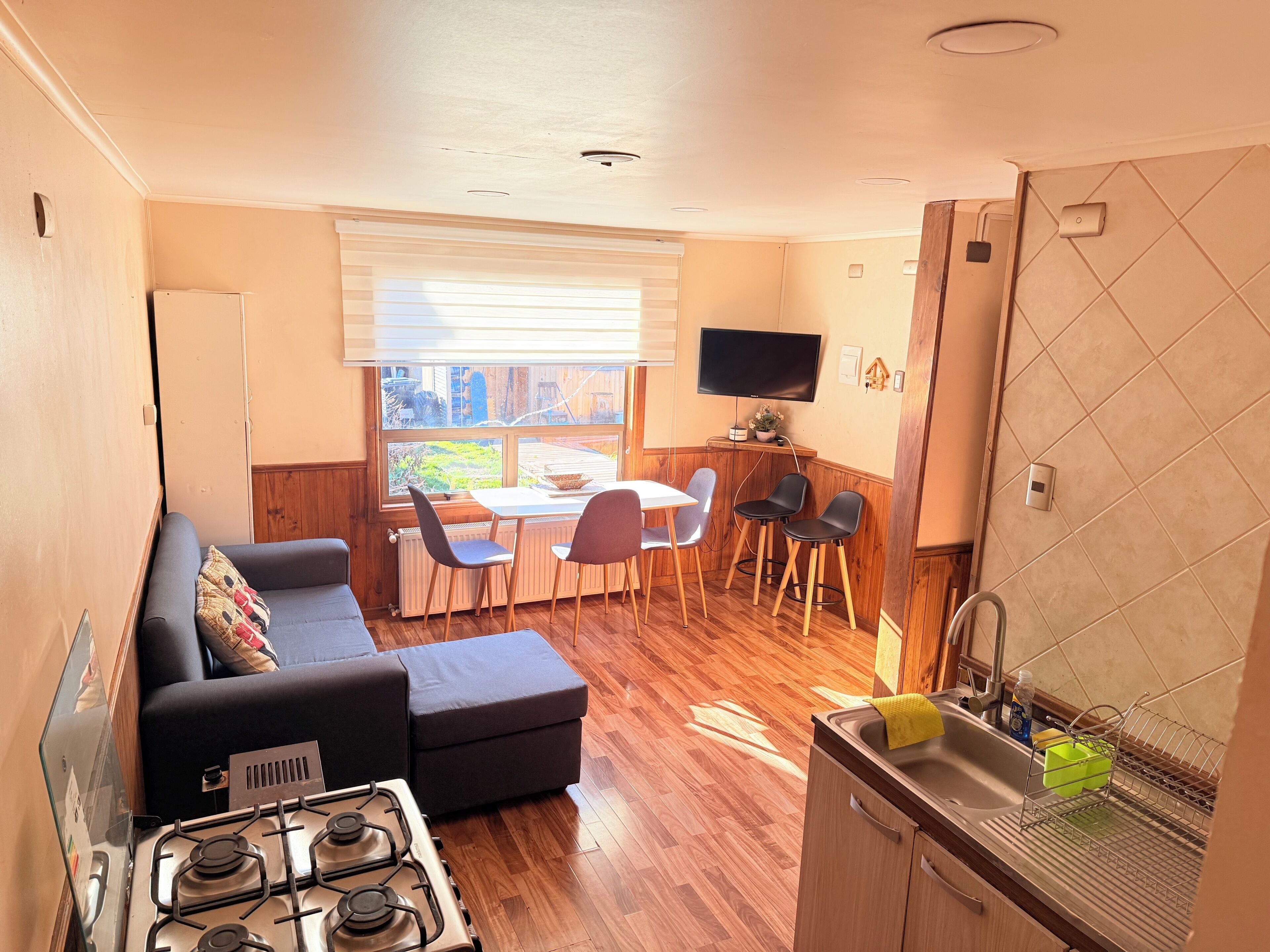 Un espace de vie compact comprenant une kitchenette, un coin repas et un canapé.