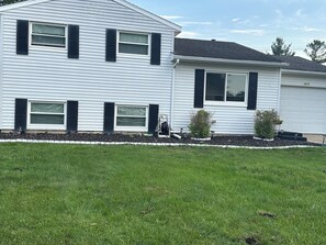 A two-story house with a front yard, a driveway, and a garage.