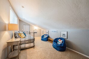 A child's bedroom with a bunk bed, a desk, bean bags, and a wall sign. - Waterfront Marco Retreat: Pool, Dock, Game Room + Beach Gear (Marco Island)