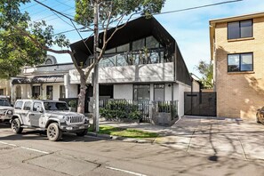 A modern two-story house with a garage, a driveway, and a tree in front. - No 5 Coppin in Yellow and Black (Richmond)