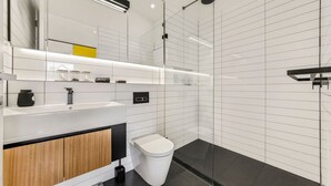 Ein modernes Badezimmer mit Waschbecken, Spiegel und Toilette in Weiß.