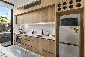 A modern kitchen with wooden cabinets, a stainless steel refrigerator, and a built-in microwave. - No 5 Coppin in Yellow and Black (Richmond)