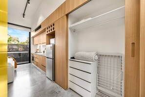 A modern kitchen with wooden cabinets, a stainless steel refrigerator, and a built-in oven. - No 5 Coppin in Yellow and Black (Richmond)