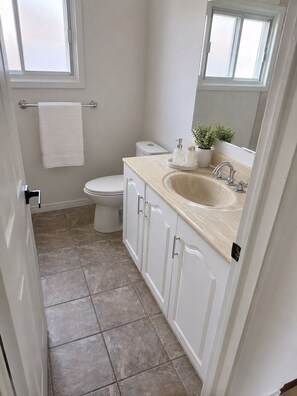 Un baño con inodoro, lavabo y espejo.