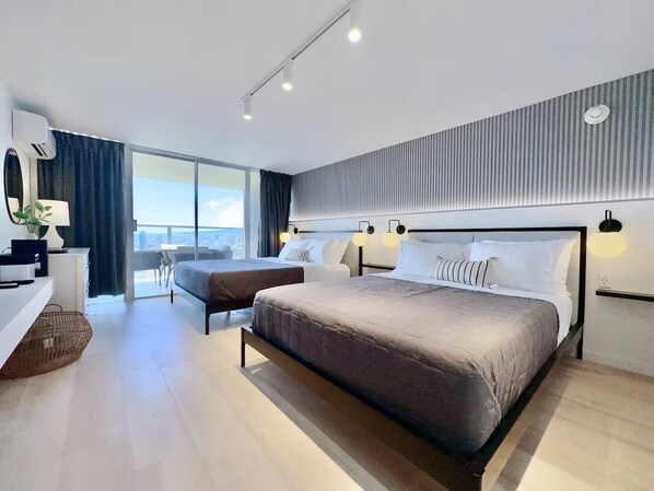 Ein modernes Hotelzimmer mit einem großen Bett, einem Schreibtisch und Blick auf die Stadt.