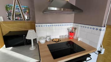 A compact kitchen with a built-in stove, a microwave, and a small countertop.