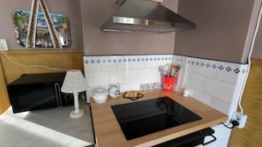 A compact kitchen with a built-in stove, a microwave, and a small countertop.