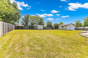 A backyard with a wooden fence, a shed, and a garage. - Spacious 4-bedroom house with large backyard near Maxwell AFB (Montgomery)